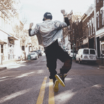 Een juichende, springen jongen met een pet die zijn rijbewijs gehaald heeft